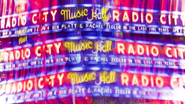 Leuchtende Radio-City-Schriftzüge in mehrfacher Spiegelung