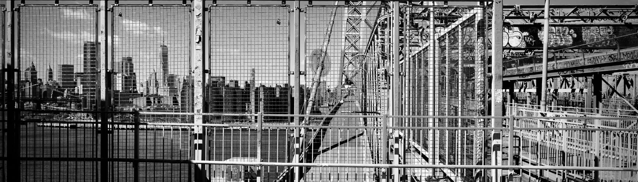 Verdichtete New Yorker Stadtlandschaft hinter Gittern und Brücken